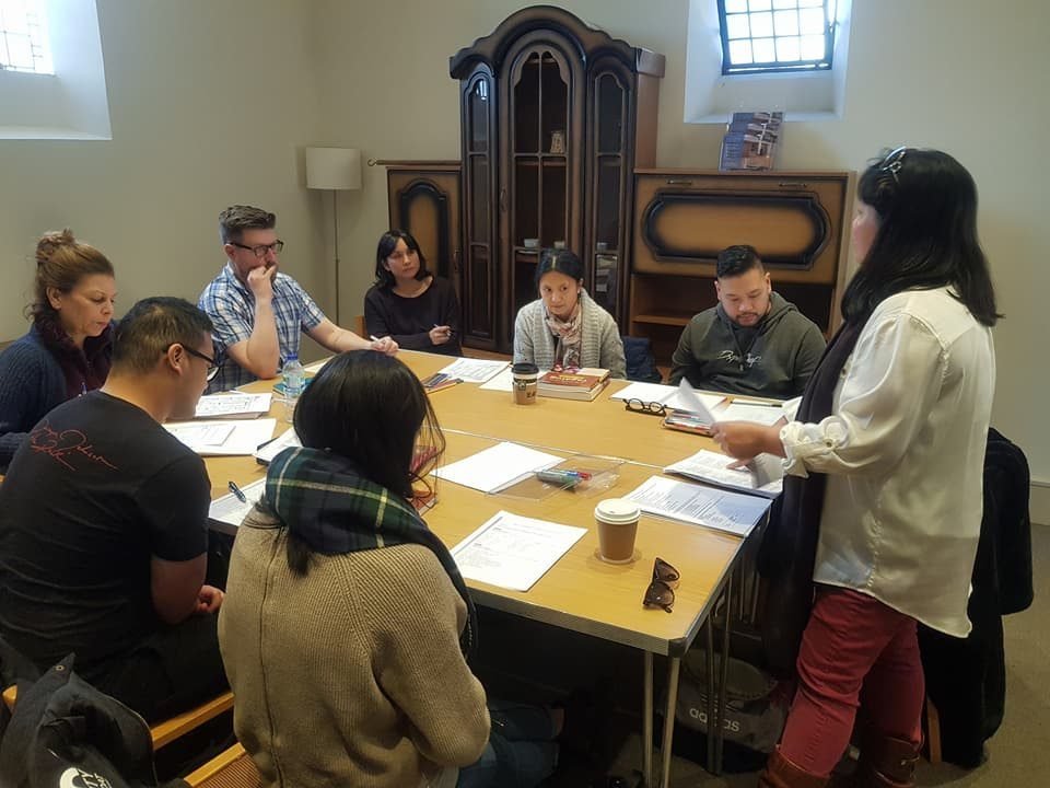 Adult Filipino class around a table, Notting Hill Gate.