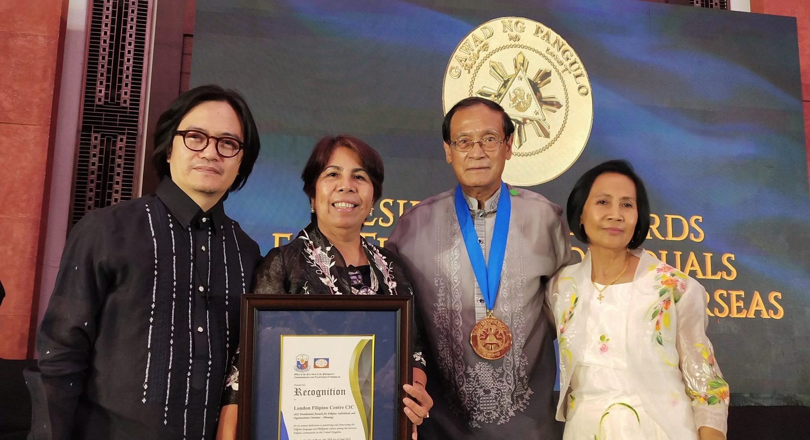 LFC representatives holding the framed Presidential Recognition and the Banaag medal.